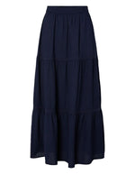 Jupe longue taille haute Tohime par Pieces de couleur bleu marine (Maritime Blue). Coupe fluide longueur cheville en pur coton avec de délicates bandes de dentelle horizontales.
