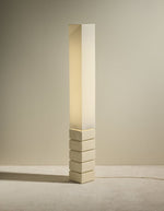 Lampadaire totem Tower allumé par Maison Sarah Lavoine. Pied élancé en céramique émaillée écru et abat-jour cylindrique en coton assorti. Design sculptural contemporain fabriqué au Portugal, hauteur 129,5 cm.
