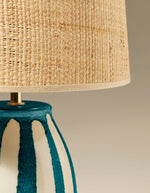 Lampe Palmaria bleu Sarah Lavoine avec pied en céramique rayé bleu et blanc, abat-jour en rabane naturelle.