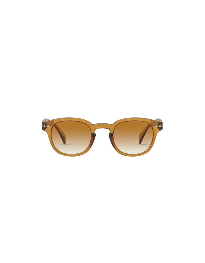 Lunettes de soleil unisexes IZIPIZI modèle #C de forme carrée vintage épaisse. La monture brillante arbore une couleur miel ocre ambrée et translucide nommée Golden Canyon, associée à des verres solaires polarisés protecteurs.