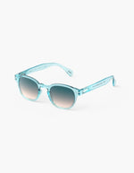 Côté des Lunettes de soleil unisexes IZIPIZI modèle #C de forme carrée vintage épaisse. La monture brillante est d'une couleur bleu turquoise translucide inspirée de la pierre turquoise, associée à des verres solaires bleus.