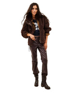Vue de face du Manteau court oversize pour femme en fourrure bouclette marron chocolat avec col camionneur zippé et cordon de serrage, modèle Sonjo de la marque BA&SH
