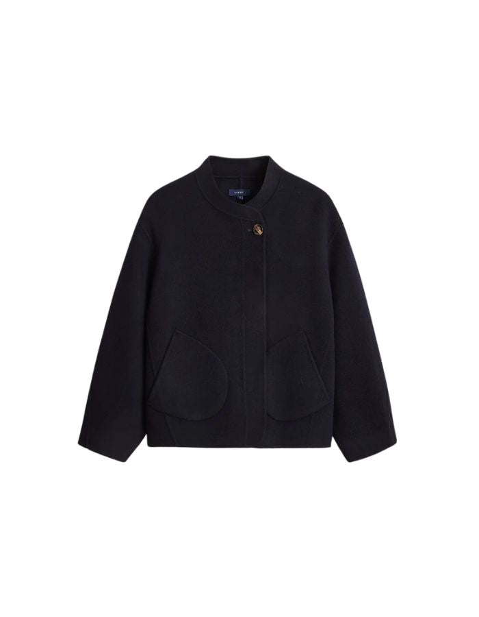 Manteau court pour femme en laine double face bleu marine profond Deep Navy, modèle Windsor de la marque SOEUR. Présente une coupe ample au volume rond, un col asymétrique, une patte de boutonnage semi-cachée et deux grandes poches plaquées sur le devant.