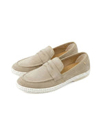 Paire de Mocassins Classic de la marque Rivieras, coloris beige. Tige en croûte de cuir de vachette, détails en ruban gros-grain et semelle blanche avec bande de coton. Fabriqués en Espagne.