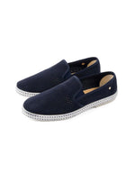 Paire de Mocassins Rivieras Classic en daim bleu marine perforé. Semelle blanche contrastée avec couture selle en coton, élastiques de confort et rivet métallique logoté sur le côté. Design intemporel fabriqué en Espagne.