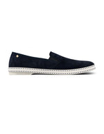 Mocassins Rivieras Classic en daim bleu marine perforé. Semelle blanche contrastée avec couture selle en coton, élastiques de confort et rivet métallique logoté sur le côté. Design intemporel fabriqué en Espagne.