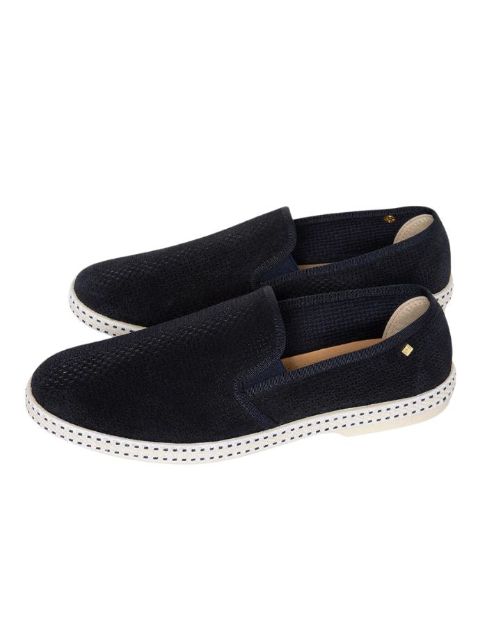 Mocassins Rivieras en suède marine avec motif embossé, semelle blanche et rivet doré.