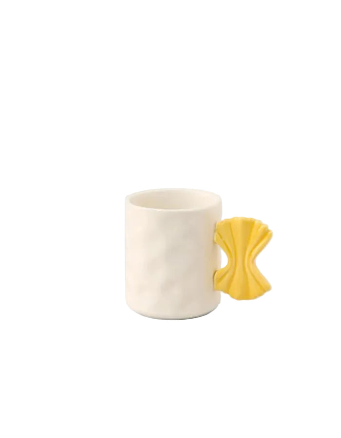 Mug en céramique blanc texturé avec anse jaune en forme de nœud papillon, design Fluid Market.