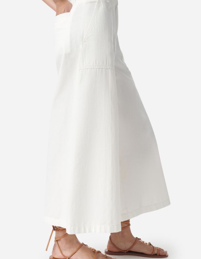 Pantalon large Griffon blanc cassé en coton-lin avec poches plaquées et sandales plates marron.