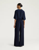 Dos du Pantalon large fluide style palace Aspen de la marque Momoni, coloris bleu uni. Coupe ample en crêpe d'acétate de soie avec plis élégants sur le devant, maxi passants à la taille et poches latérales.