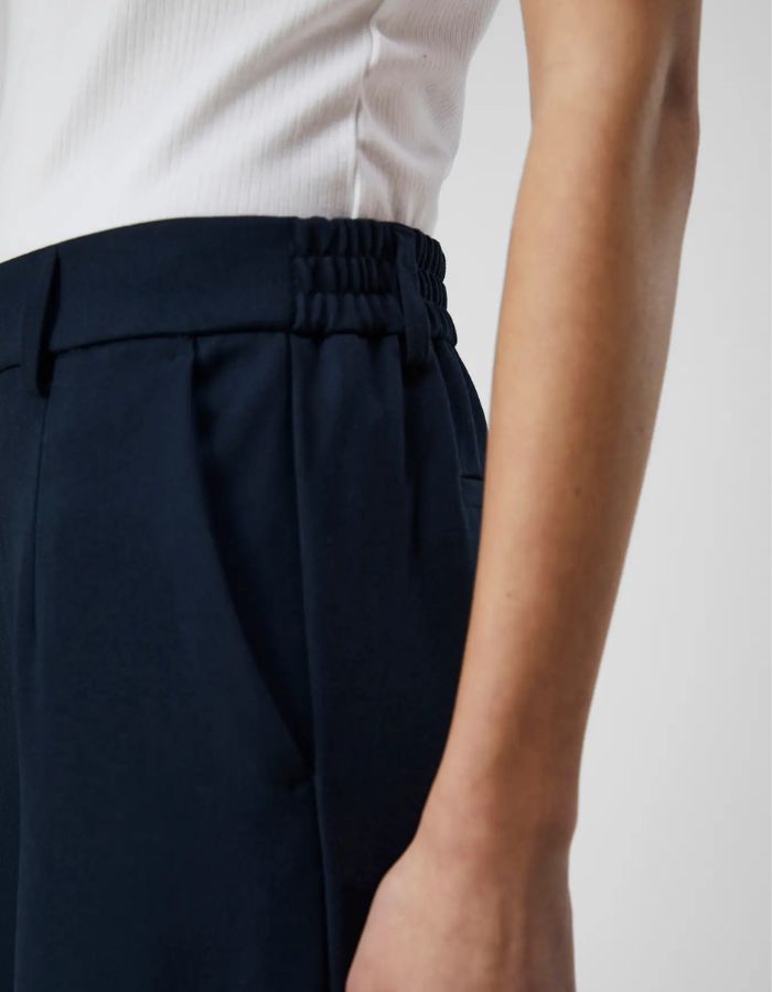 Poche du Pantalon large pour femme de couleur bleu marine foncé Sky Captain, modèle Lisa Wide Pant de la marque Object. Présente une coupe droite très ample de style wide-leg, une taille mi-haute froncée par un élastique confortable et des poches discrètes insérées dans les coutures latérales.