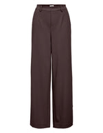 Pantalon large pour femme de couleur marron foncé chocolat Seal Brown, modèle Lisa Wide Pant de la marque Object. Présente une coupe droite très ample de style wide-leg, une taille mi-haute froncée par un élastique confortable et des poches discrètes insérées dans les coutures latérales.