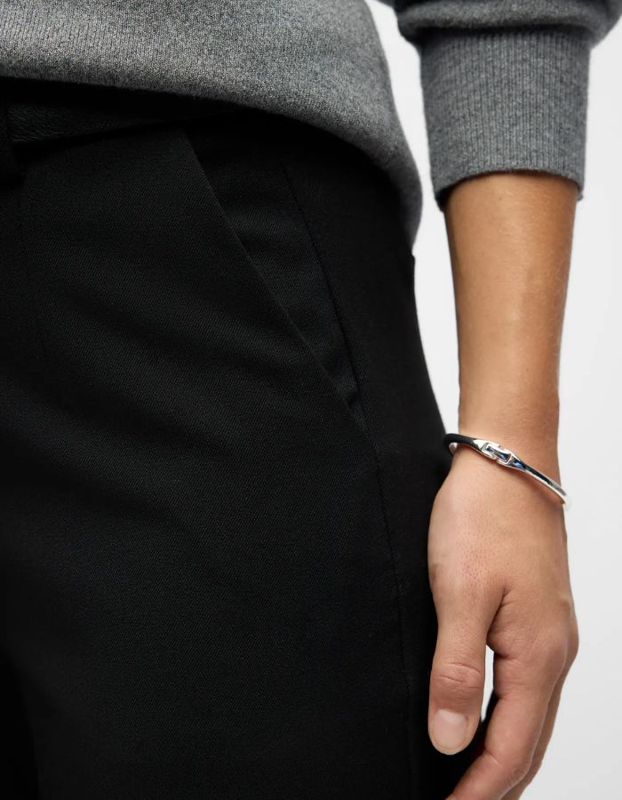 Poche du Pantalon large pour femme de couleur noir uni opaque, modèle Lisa Wide Pant de la marque Object. Présente une coupe droite très ample de style wide-leg, une taille mi-haute froncée par un élastique confortable et des poches discrètes insérées dans les coutures latérales.