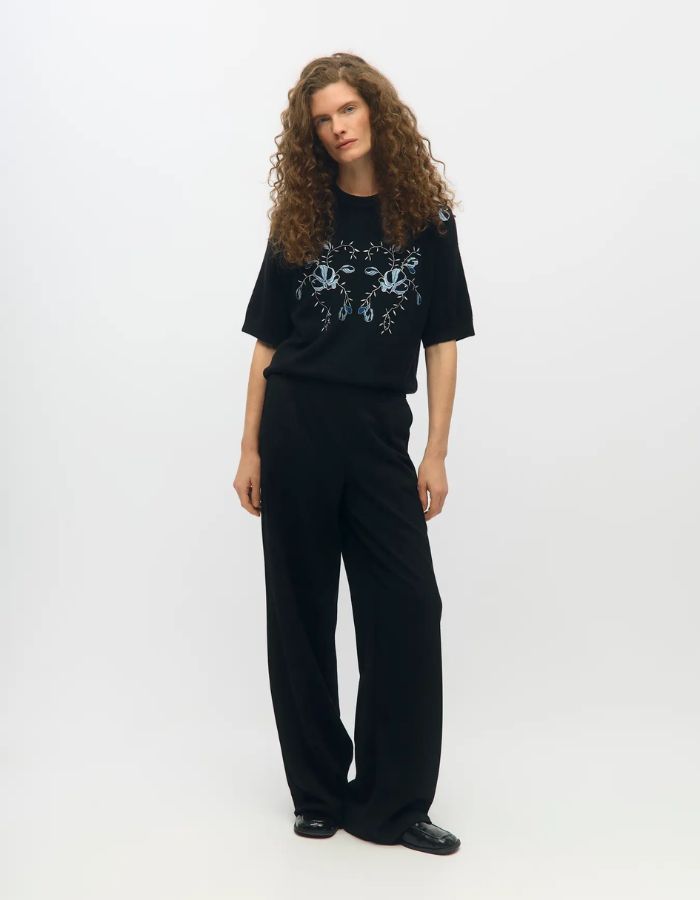 Silhouette avec le Pantalon large pour femme de couleur noir uni opaque, modèle Lisa Wide Pant de la marque Object. Présente une coupe droite très ample de style wide-leg, une taille mi-haute froncée par un élastique confortable et des poches discrètes insérées dans les coutures latérales.