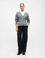 Silhouette avec le Pantalon large pour femme de couleur noir uni opaque, modèle Lisa Wide Pant de la marque Object. Présente une coupe droite très ample de style wide-leg, une taille mi-haute froncée par un élastique confortable et des poches discrètes insérées dans les coutures latérales.