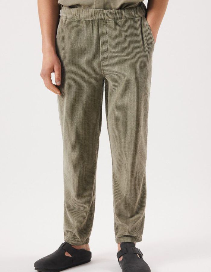 Vue de face du Pantalon en velours côtelé pour homme de couleur beige argile clair Argile Vintage, modèle Padow de la marque American Vintage. Présente une coupe droite ample d'inspiration jogging avec une taille élastiquée dotée d'un lien de resserrage et des poches italiennes.