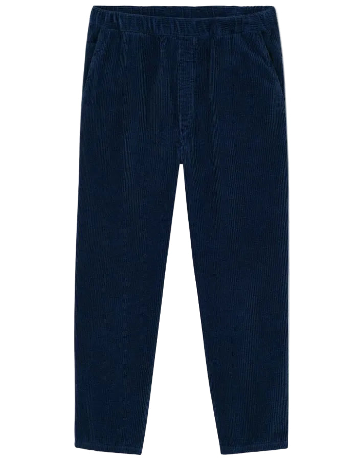 Pantalon en velours côtelé pour homme de couleur bleu marine foncé Navy Vintage, modèle Padow de la marque American Vintage. Présente une coupe droite ample d'inspiration jogging avec une taille élastiquée dotée d'un lien de resserrage et des poches italiennes.