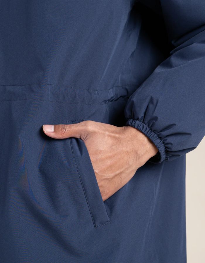 Poche de la Parka imperméable mixte bleu indigo pour homme et femme, modèle Pompidou de la marque Flotte. Présente une coupe ajustée avec cordon de serrage à la taille, fermetures zippées étanches et doublure en polaire chaude.