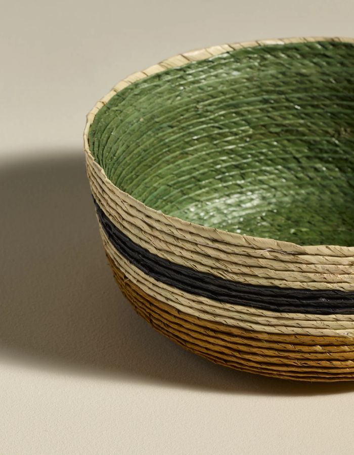Finition du Petit panier rond Globe par Maison Sarah Lavoine. Tressage artisanal en fibres de palmier avec rayures horizontales Eucalyptus et Ocre, fabriqué au Mexique, dimensions H7 x Ø20 cm.