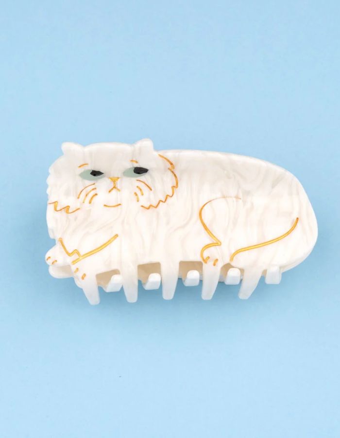 Pince à cheveux crabe de taille moyenne de la marque Coucou Suzette en acétate de cellulose couleur crème marbré. L'accessoire représente un chat persan frangé au visage boudeur avec de grands yeux bleus clairs.
