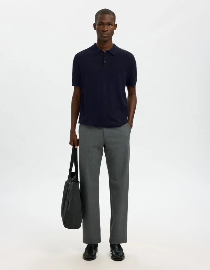 Homme portant un polo Navy Berg en maille plate avec manches courtes et poignets côtelés, coupe regular.
