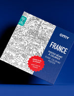 Boîte bleue et blanche du poster géant à colorier OMY France, avec illustrations détaillées de monuments français.