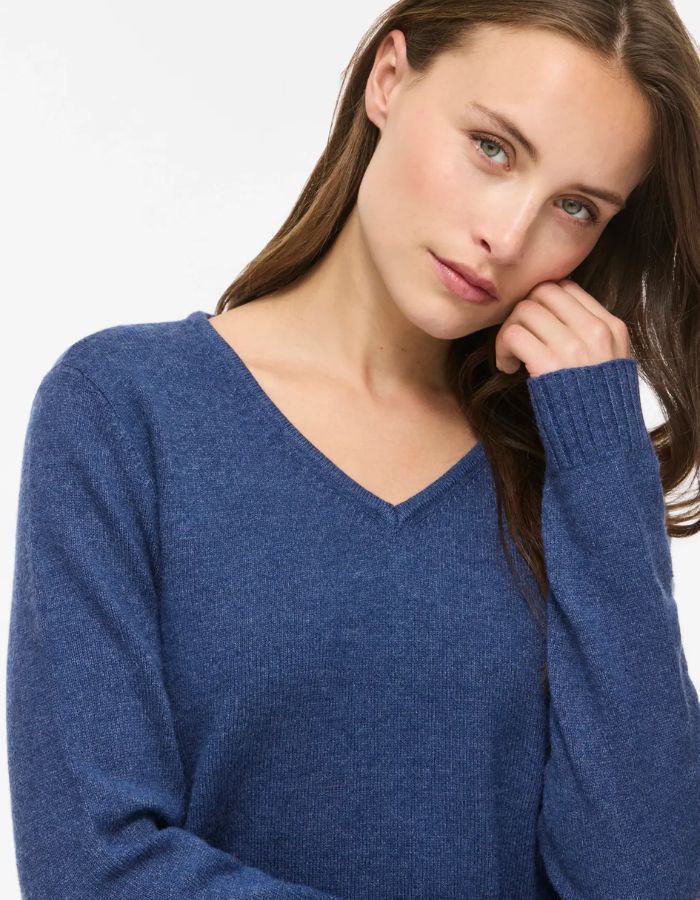 Détail du Pull en maille fine pour femme à manches longues et col en V, modèle Viril de la marque Vila. Tissu tricoté de couleur bleu marine foncé mélangé Navy Peony avec des finitions en bords-côtes aux poignets.