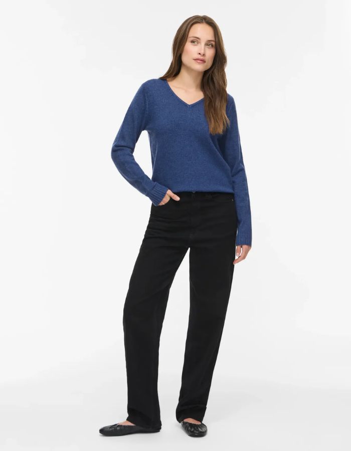 Silhouette avec le Pull en maille fine pour femme à manches longues et col en V, modèle Viril de la marque Vila. Tissu tricoté de couleur bleu marine foncé mélangé Navy Peony avec des finitions en bords-côtes aux poignets.