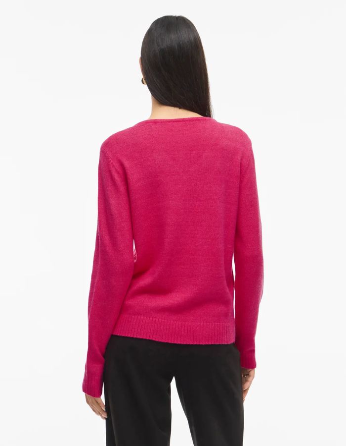 Vue de dos du Pull en maille fine pour femme modèle Viril de la marque Vila. Coupe droite avec un col en V élégant et des manches longues aux poignets côtelés, couleur rose fuchsia uni et lumineux.
