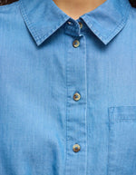 Robe chemise en chambray bleu clair avec col, patte de boutonnage et poche poitrine.