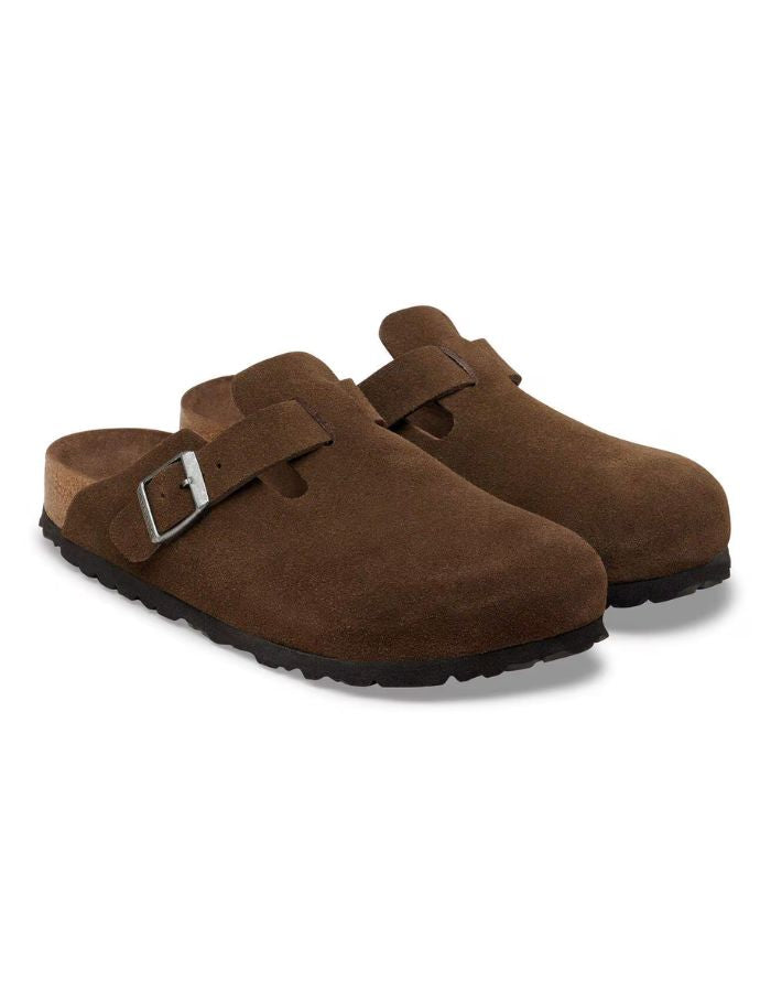 Paire de Sabots fermés modèle Boston de la marque Birkenstock en cuir velours souple de couleur marron foncé Carafe. Présente une bride ajustable à boucle métallique sur le dessus et une semelle anatomique ton sur ton en liège avec lit de pied souple, version chaussant étroit.