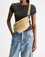 Sac banane Hosie sable Bellerose en nylon matelassé, porté croisé.