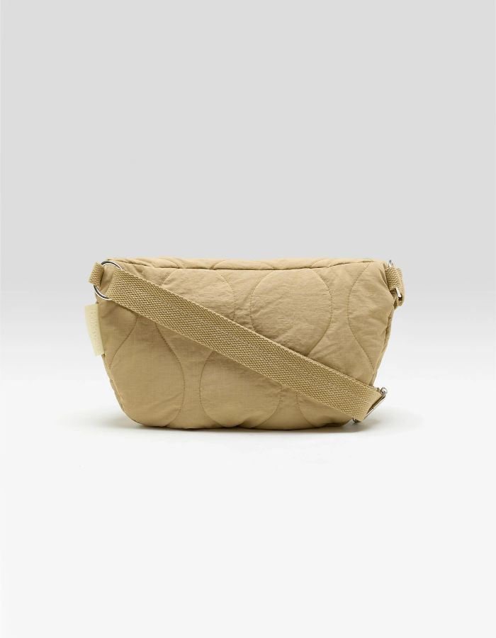 Sac banane Hosie sable Bellerose en nylon matelassé, forme demi-lune avec bandoulière ajustable.