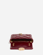 Ouverture du Moyen sac bandoulière pour femme en cuir de vachette craquelé bordeaux cerise avec fermoir rond doré et bandoulière chaîne, modèle Moyen Sac Moon Cuir Craquelé couleur Cerise de Vanessa Bruno.