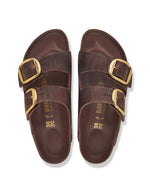 dessus des Sandales Birkenstock modèle Arizona Big Buckle avec chaussant étroit. Présente deux larges brides en cuir huilé épais à bords bruts dotées de grandes boucles métalliques élégantes, montées sur la célèbre semelle anatomique en liège et cuir lisse assorti.