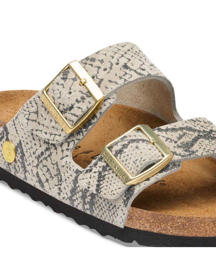 Boucle des Sandales pour pieds fins en largeur Narrow, modèle emblématique Arizona Rivet Logo de la marque Birkenstock. Confectionnées en cuir velours souple de couleur claire beige huître Snake Oyster, elles présentent deux brides horizontales ajustables avec boucles en métal, un rivet logo et la célèbre semelle anatomique marron en liège naturel