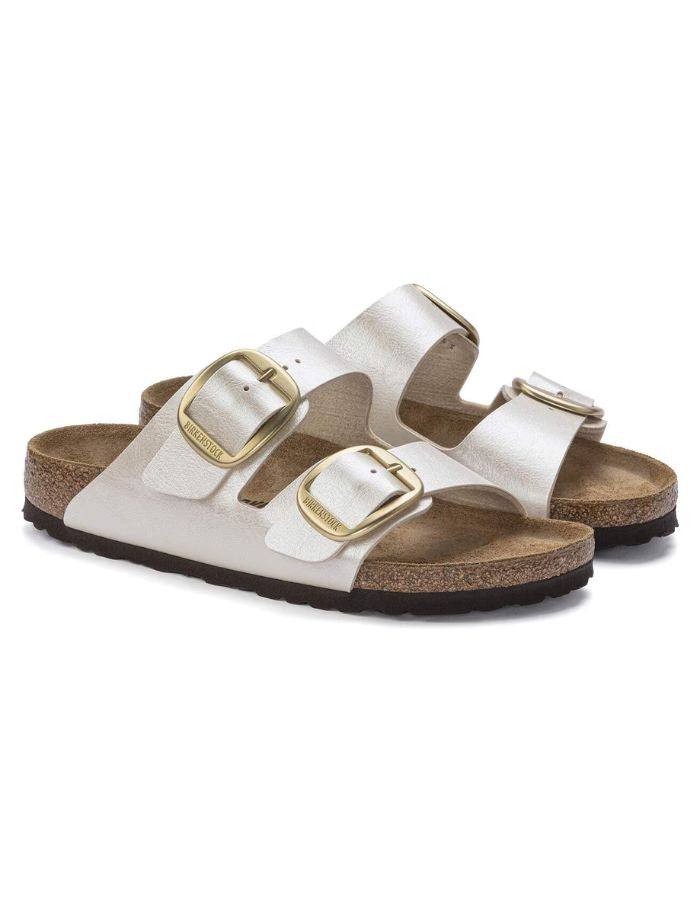 Paire de Sandales Birkenstock Arizona Big Buckle en largeur étroite. Les deux brides réglables sont en Birko-Flor® blanc nacré satiné (Graceful Pearl White) avec de grandes boucles en métal argenté, reposant sur une semelle anatomique en liège et cuir velours.