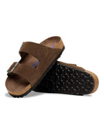 Semelle des Sandales Birkenstock modèle Arizona avec chaussant étroit. Présente deux brides ajustables en cuir velours souple de couleur marron foncé Carafe avec des boucles en métal assorties, montées sur la célèbre semelle anatomique en liège avec lit de pied souple.