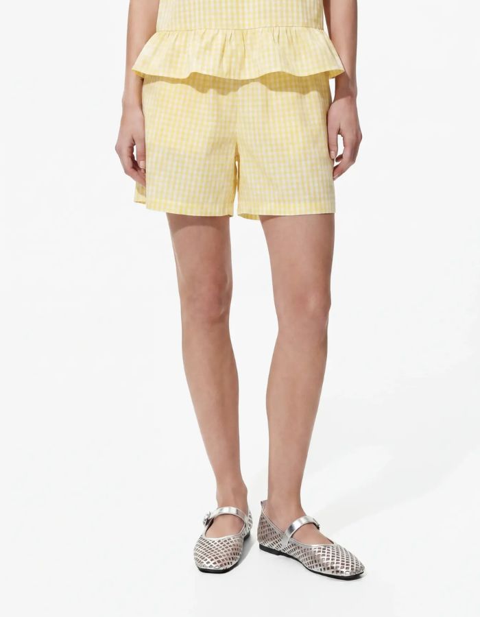 Vue de face du Short de la marque PIECES motif Vichy jaune et blanc. Coupe taille haute avec ceinture élastique et coupe standard (regular fit). Matière durable en coton biologique et fibres recyclées.