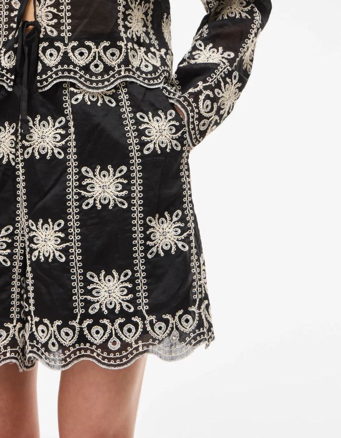 Détail du Short taille haute fluide Nala par Rouge Edit, coloris noir Meteorite Embroidery. Coupe large avec poches latérales et broderies ton sur ton élégantes. Tissu soyeux en mélange de lyocell.
