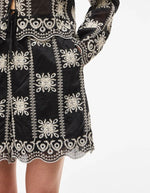 Détail du Short taille haute fluide Nala par Rouge Edit, coloris noir Meteorite Embroidery. Coupe large avec poches latérales et broderies ton sur ton élégantes. Tissu soyeux en mélange de lyocell.