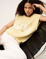 Sweat Beata Jaune Ba&sh sans manches en coton biologique avec logo blanc, porté par une femme.