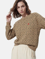 Vue de face du Sweatshirt à col rond et manches longues pour femme avec un imprimé léopard noir et marron sur fond blanc cassé, modèle Greta de la marque PIECES. Présente une broderie rouge vif en forme de cœur sur le côté gauche de la poitrine.
