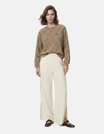 Silhouette avec le Sweatshirt à col rond et manches longues pour femme avec un imprimé léopard noir et marron sur fond blanc cassé, modèle Greta de la marque PIECES. Présente une broderie rouge vif en forme de cœur sur le côté gauche de la poitrine.