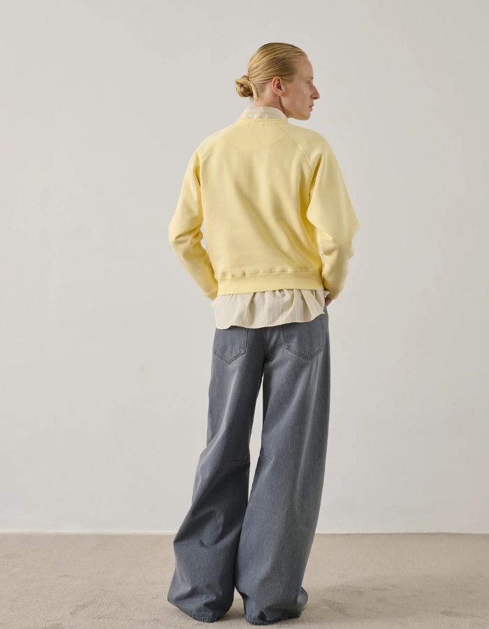 Mannequin portant un sweatshirt Artemis jaune pâle en coton biologique avec broderie "Sœur", coupe droite.