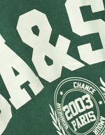 Sweatshirt Fenja Emeraude vert émeraude avec grand logo blanc et badge "2003 Paris" style campus.