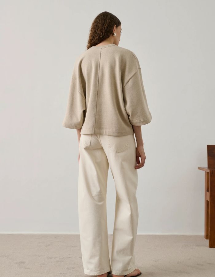 Sweatshirt Iksan beige chiné oversize à manches courtes et surpiqûre dos, porté avec un pantalon clair.