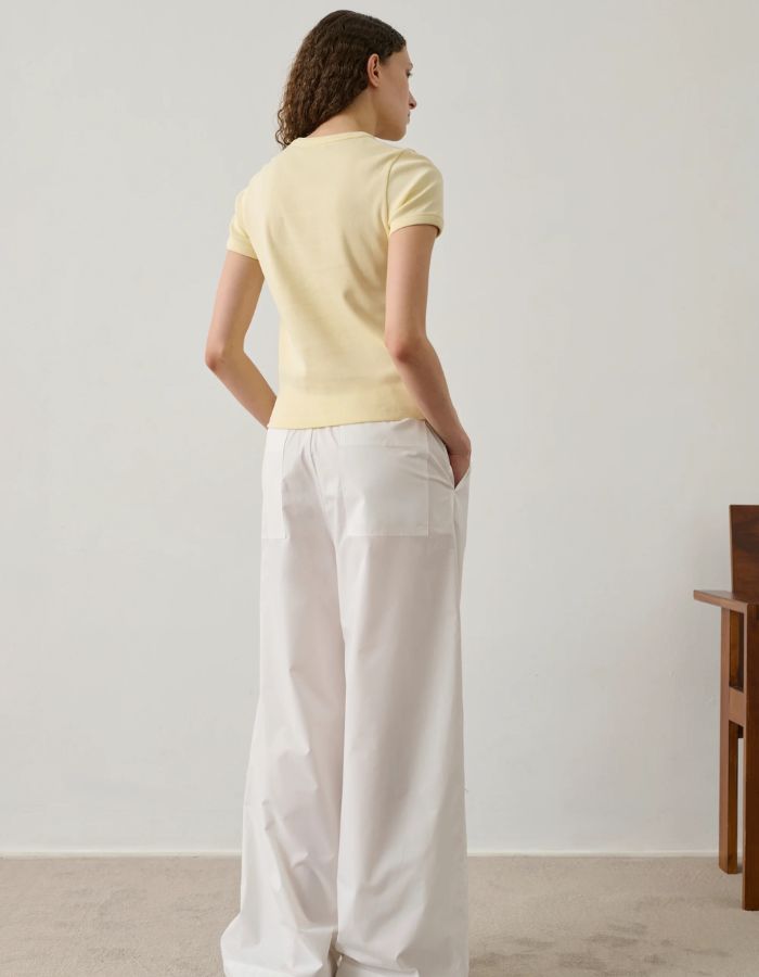 Femme portant un tee-shirt Aristide jaune pâle en coton biologique, coupe étroite, manches courtes, col rond.