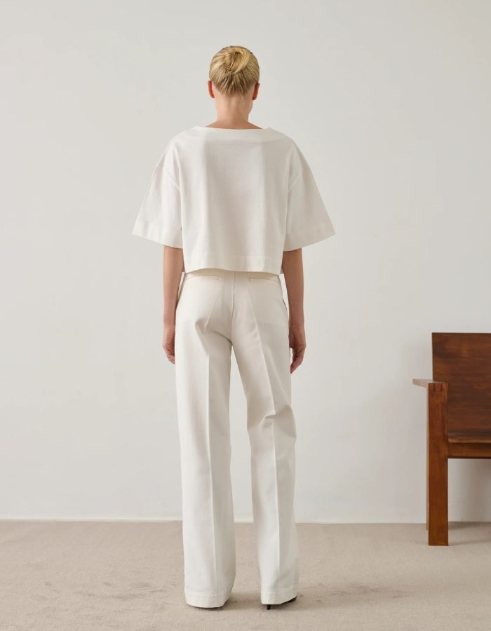 Dos d'une femme portant le T-Shirt Davina Blanc Cassé en coton organique, coupe ample et courte, col bateau.