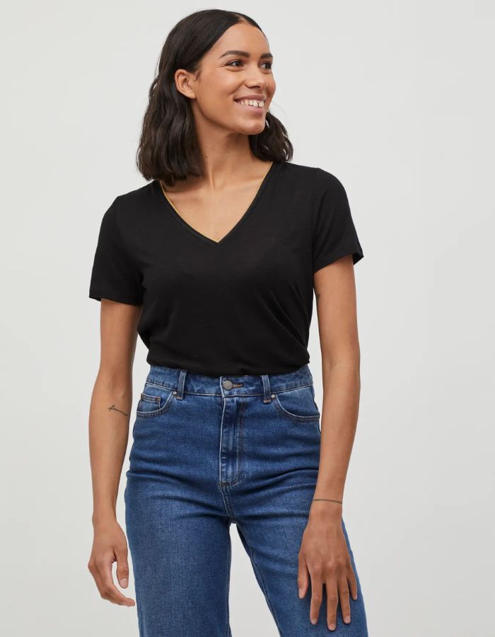 Silhouette avec le T-shirt noir uni pour femme modèle Noel de la marque Vila. Design classique à manches courtes et col en V, réalisé dans une maille jersey fluide et extensible